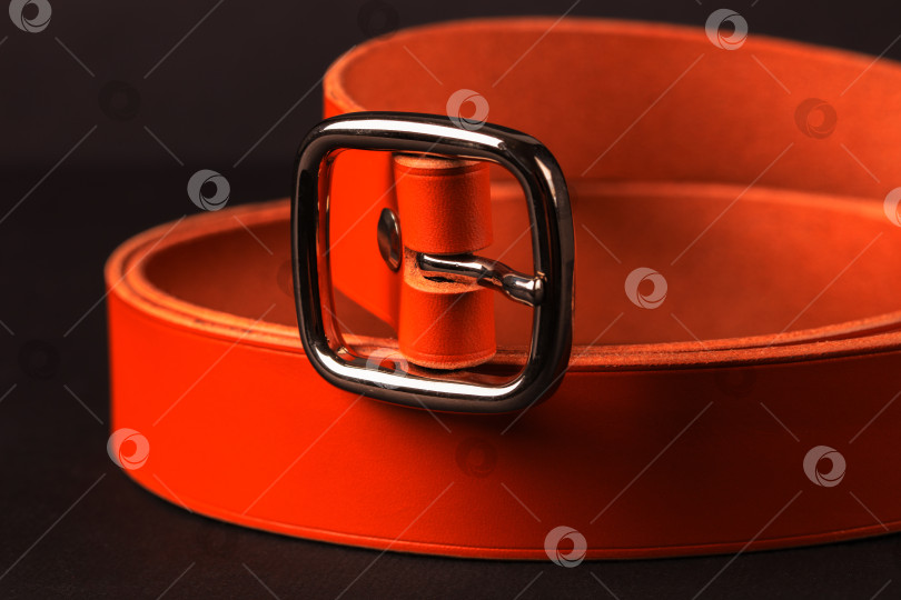 Скачать Ремень с серебряной пряжкой оранжевого цвета. Ремень изготовлен из кожи и имеет квадратную пряжку фотосток Ozero