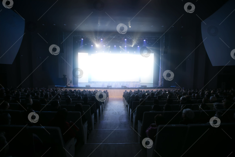 Скачать Зрители с нетерпением ждут представления в тускло освещенной театральной обстановке при ярком освещении сцены фотосток Ozero