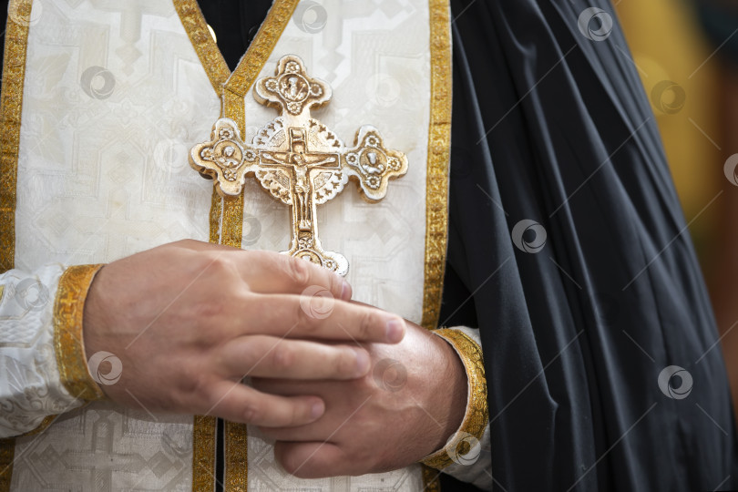 Скачать Священнослужитель с украшенным крестом в руках во время религиозной церемонии в исторической церкви фотосток Ozero
