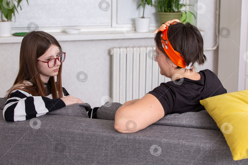 Скачать Беседа между девушкой и женщиной в солнечный день в уютной гостиной, окруженной растениями фотосток Ozero