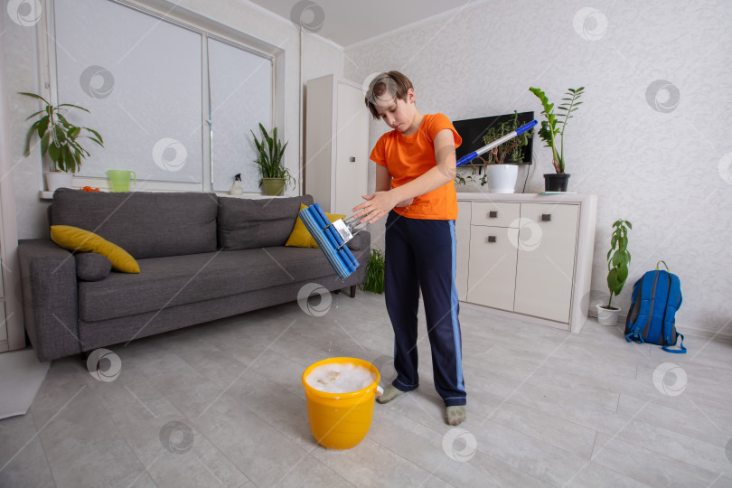 Скачать Ребенок убирает гостиную со шваброй и ведром фотосток Ozero