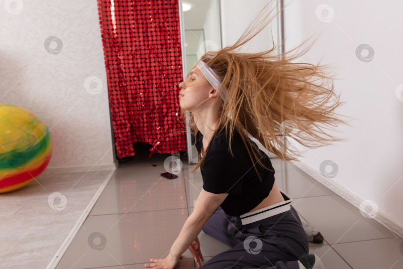 Скачать Танцовщица, выполняющая динамичные движения в помещении с ярким декором и красочным мячом для упражнений на заднем плане фотосток Ozero