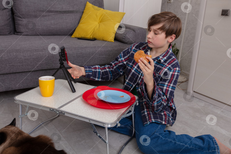 Скачать Молодой парень наслаждается перекусом во время записи видео дома фотосток Ozero
