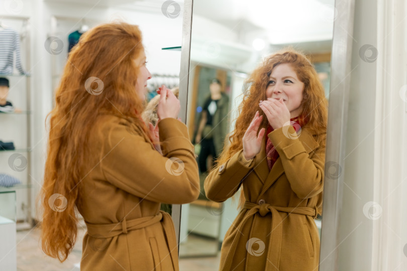 Скачать Женщина с рыжими волосами стоит перед зеркалом фотосток Ozero