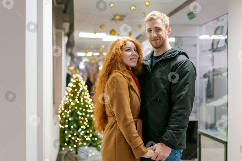 Скачать Мужчина и женщина стоят перед рождественской елкой фотосток Ozero