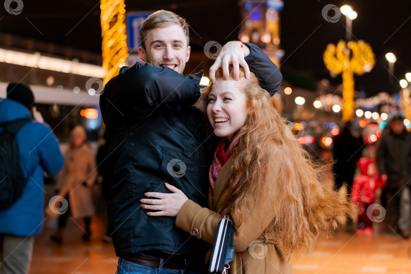 Скачать Мужчина и женщина обнимают друг друга на оживленной городской улице фотосток Ozero