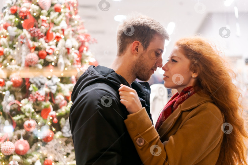 Скачать Мужчина и женщина целуются перед рождественской елкой фотосток Ozero