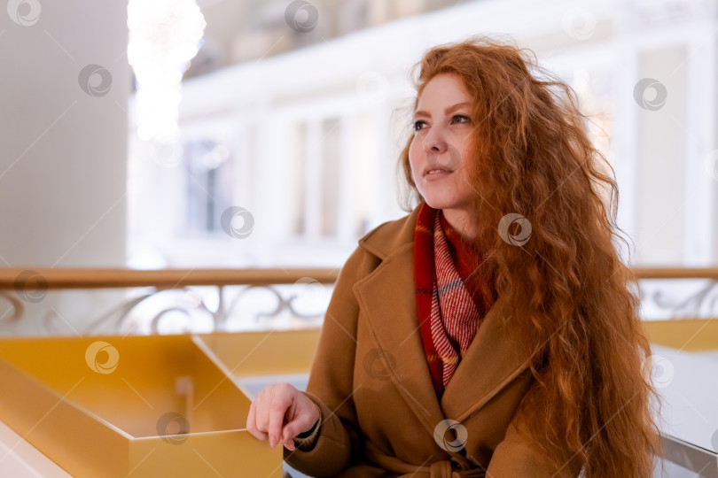 Скачать Женщина с рыжими волосами сидит на скамейке фотосток Ozero