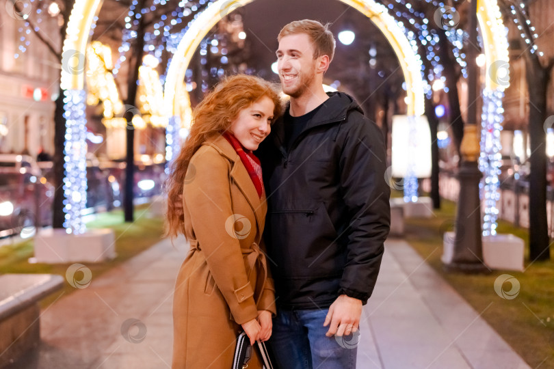 Скачать Мужчина и женщина стоят перед рождественской аркой фотосток Ozero