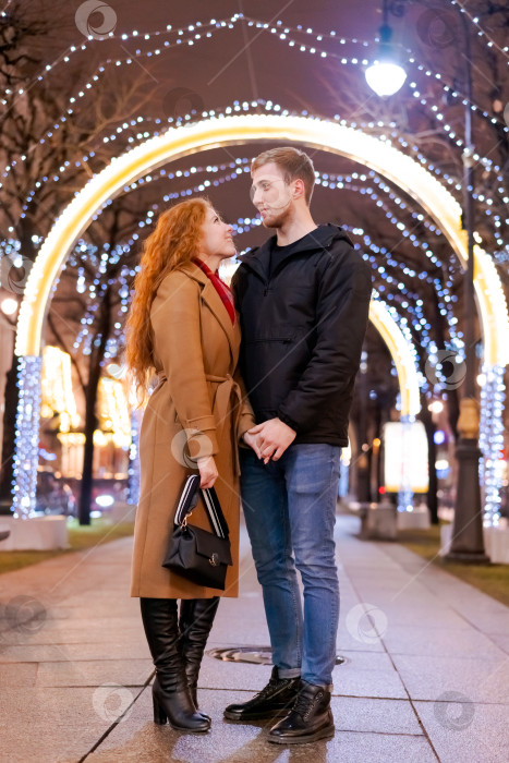 Скачать Мужчина и женщина стоят перед освещенной аркой фотосток Ozero