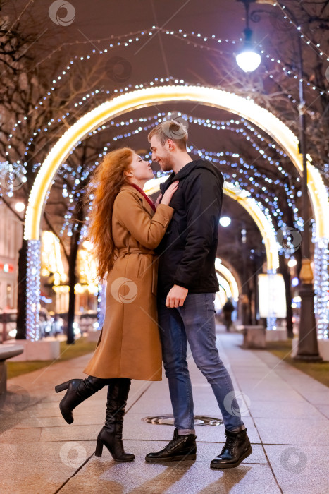 Скачать Мужчина и женщина целуются перед рождественской аркой фотосток Ozero