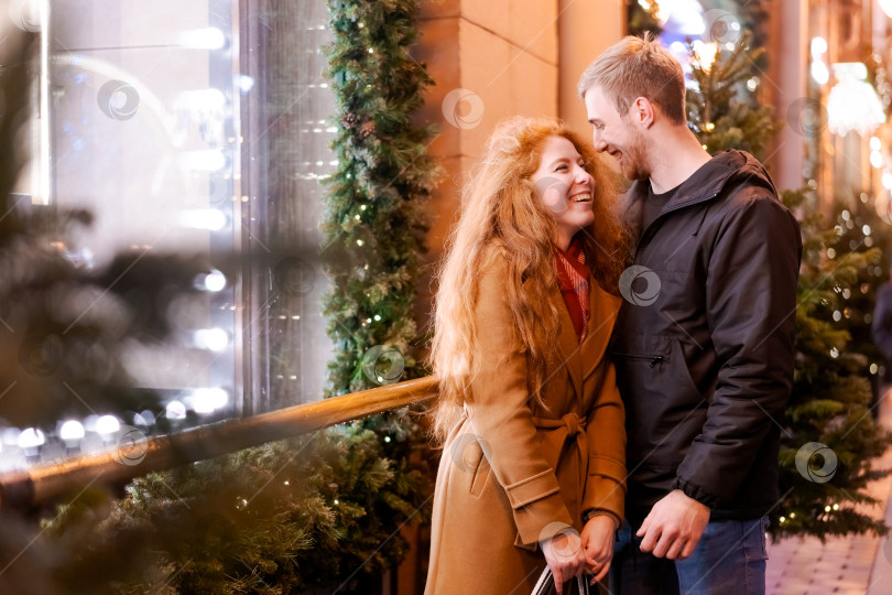 Скачать Мужчина и женщина стоят перед рождественской елкой фотосток Ozero