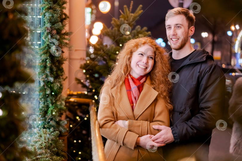 Скачать Мужчина и женщина стоят перед рождественской елкой фотосток Ozero