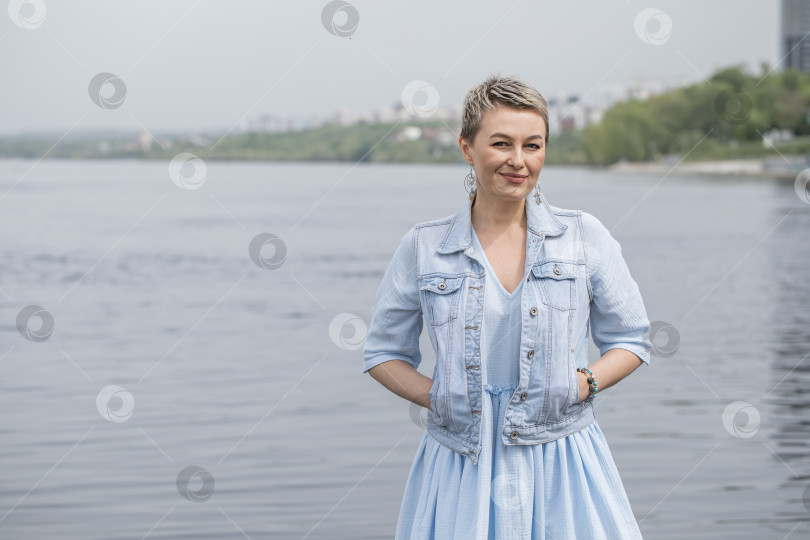 Скачать Модный портрет блондинки средних лет в джинсовой куртке фотосток Ozero