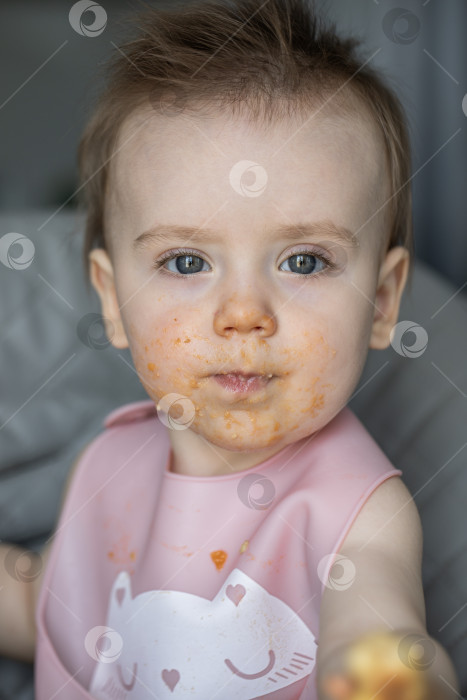 Скачать Маленькая девочка вкусно ест, сидя за детским столиком фотосток Ozero