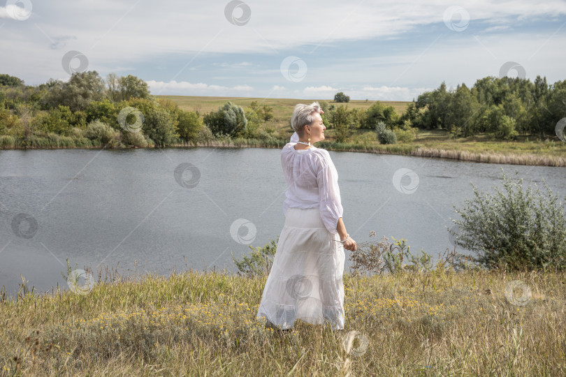 Скачать Портрет женщины средних лет в полный рост на фоне озера фотосток Ozero
