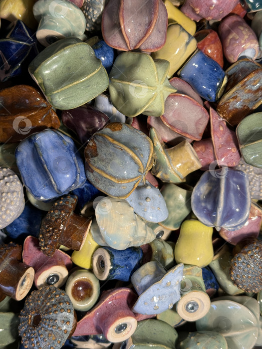 Скачать Разнообразные разноцветные керамические бусины, собранные в стопку, идеально подходят для создания фона для рукоделия или декора фотосток Ozero