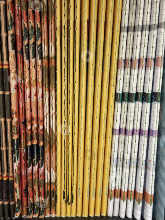 Скачать Сложенные в стопку красочные блокноты с абстрактным рисунком создают текстурированный, яркий фон фотосток Ozero