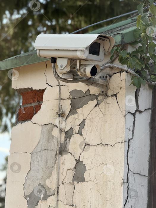 Скачать Камера видеонаблюдения, установленная на потрескавшейся стене здания, демонстрирует упадок городов и инфраструктуры фотосток Ozero