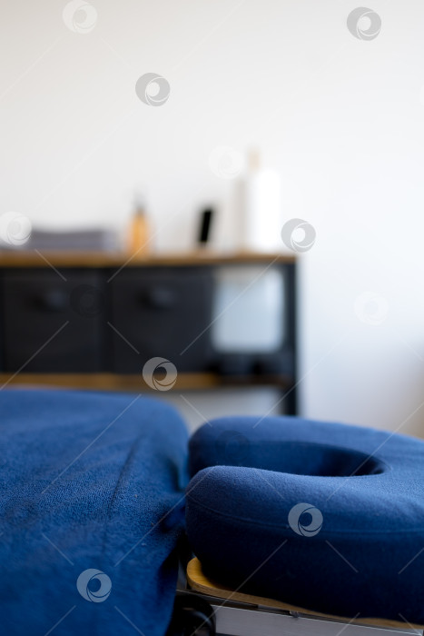 Скачать крупный план подголовника кушетки. Подставка для лица на массажном столе с полотенцем наготове для клиента фотосток Ozero