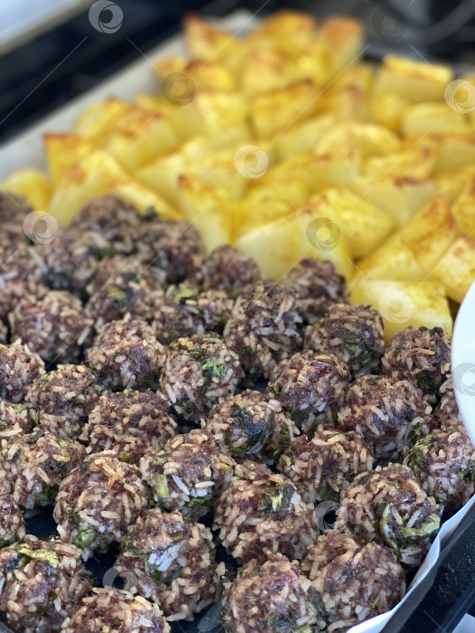 Скачать Запеченные фрикадельки с картофелем на подносе - идеальное дополнение к домашнему блюду фотосток Ozero