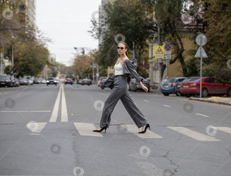 Скачать Молодая деловая женщина, идущая по пешеходному переходу фотосток Ozero