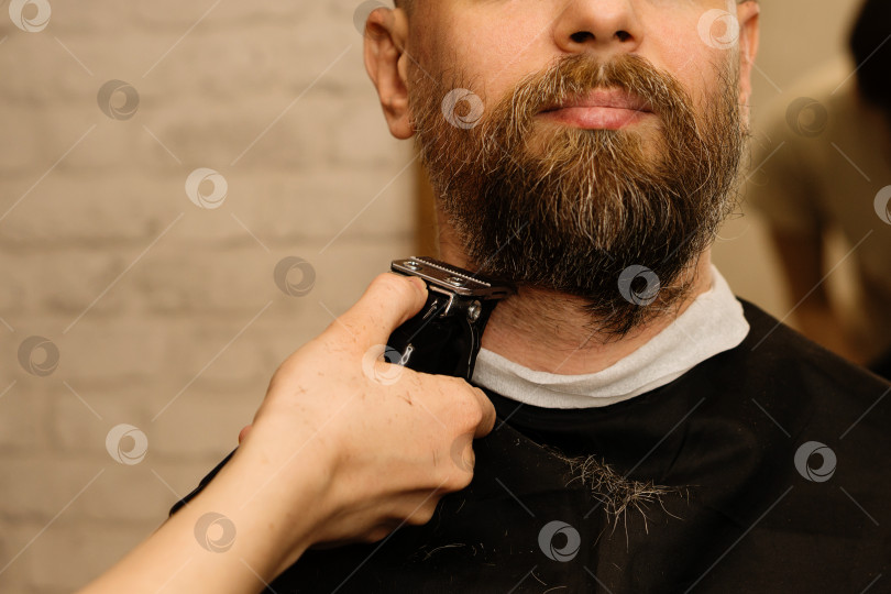 Скачать Парикмахер подстригает бороду электрической бритвой фотосток Ozero