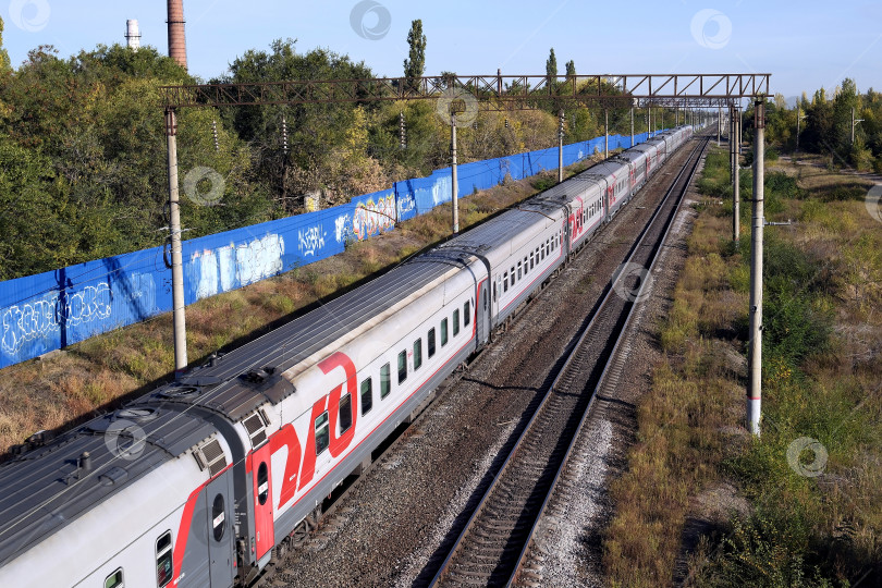 Скачать Пассажирский поезд приближается к железнодорожной станции фотосток Ozero