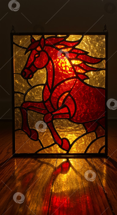 Скачать Художественный витраж "Красная лошадь" со светом создает узор на деревянном полу. фотосток Ozero