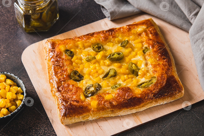 Скачать Традиционная мексиканская пицца с халапеньо, сыром и кукурузой на доске на столе фотосток Ozero