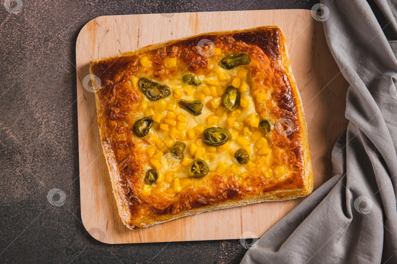 Скачать Острая пицца с перцем халапеньо, кукурузой и сыром крупным планом на деревянной доске, вид сверху фотосток Ozero