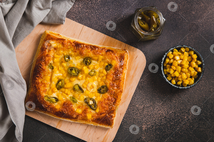 Скачать Острая пицца с перцем халапеньо, кукурузой и сыром на деревянной доске, вид сверху фотосток Ozero