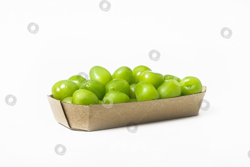 Скачать Свежий зеленый виноград в картонной коробке на белом фоне. Изолированный. Вид сбоку фотосток Ozero