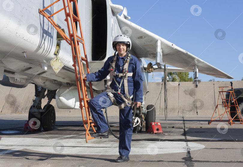 Скачать Военный летчик в шлеме стоит возле реактивного самолета фотосток Ozero