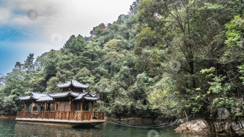 Скачать К берегу озера пришвартована красивая китайская лодка. фотосток Ozero