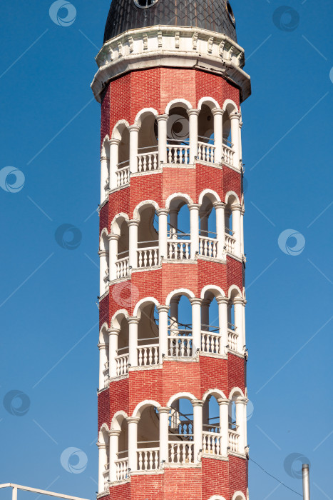 Скачать Фрагмент высокой башни из красного кирпича с белыми колоннами фотосток Ozero