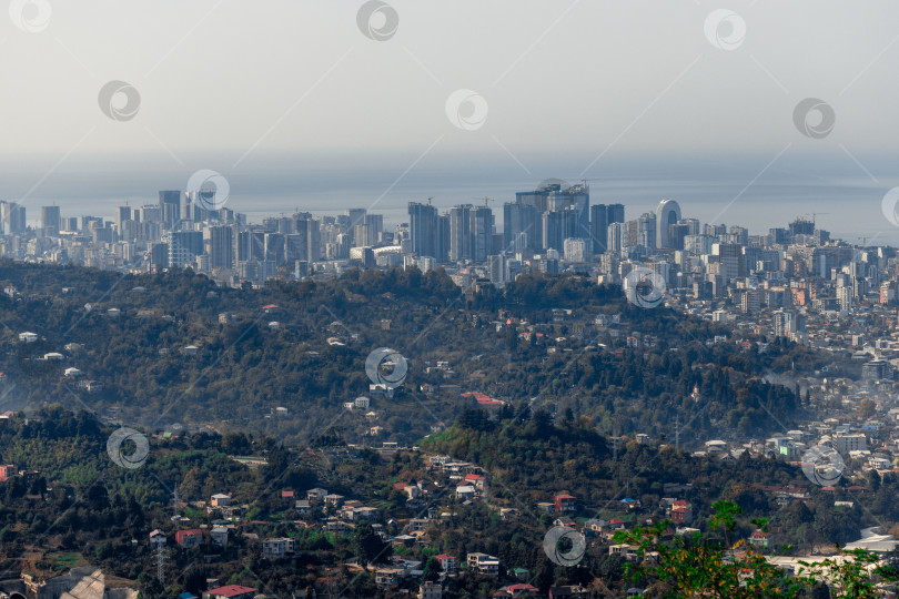 Скачать Сельская местность в Грузии. Сельские дома, расположенные на склонах гор. На заднем плане - небоскребы Батуми. фотосток Ozero