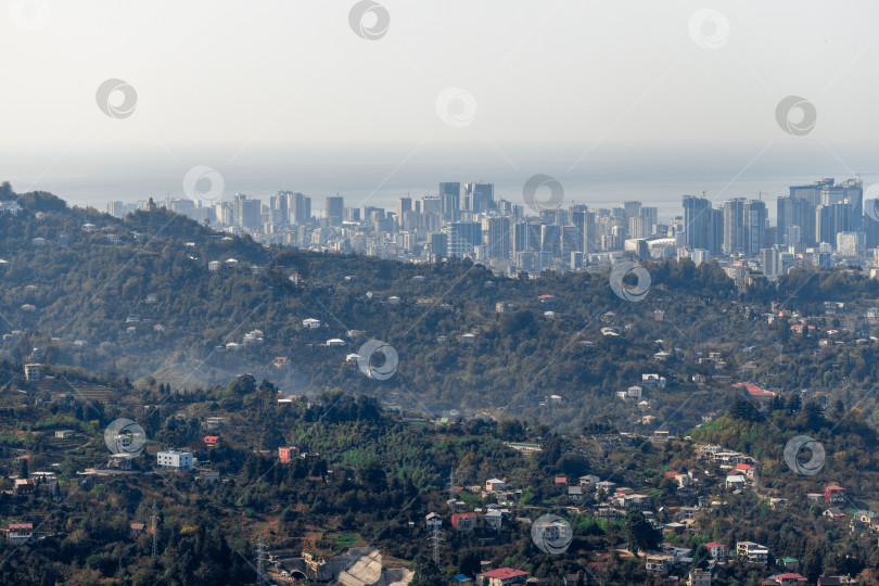 Скачать Сельская местность в Грузии. Сельские дома, расположенные на склонах гор. На заднем плане - небоскребы Батуми. фотосток Ozero