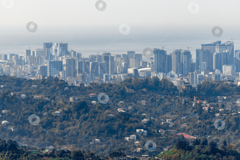 Скачать Сельская местность в Грузии. Сельские дома, расположенные на склонах гор. На заднем плане - небоскребы Батуми. фотосток Ozero