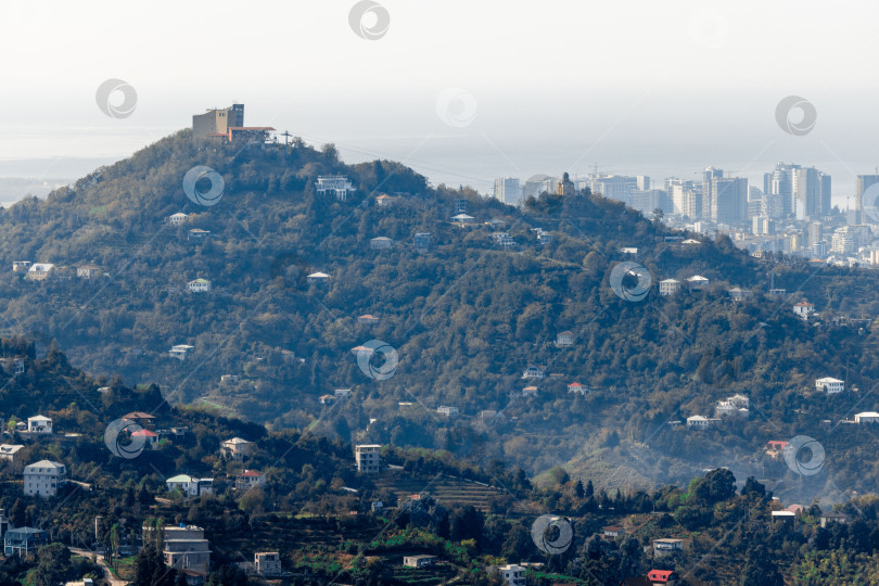 Скачать Сельская местность в Грузии. Сельские дома, расположенные на склонах гор. На заднем плане - небоскребы Батуми. фотосток Ozero