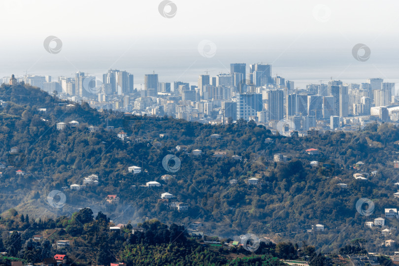 Скачать Сельская местность в Грузии. Сельские дома, расположенные на склонах гор. На заднем плане - небоскребы Батуми. фотосток Ozero