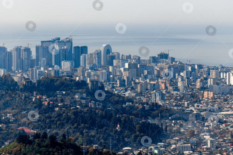 Скачать Сельская местность в Грузии. Сельские дома, расположенные на склонах гор. На заднем плане - небоскребы Батуми. фотосток Ozero