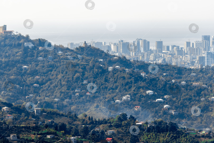 Скачать Сельская местность в Грузии. Сельские дома, расположенные на склонах гор. На заднем плане - небоскребы Батуми. фотосток Ozero