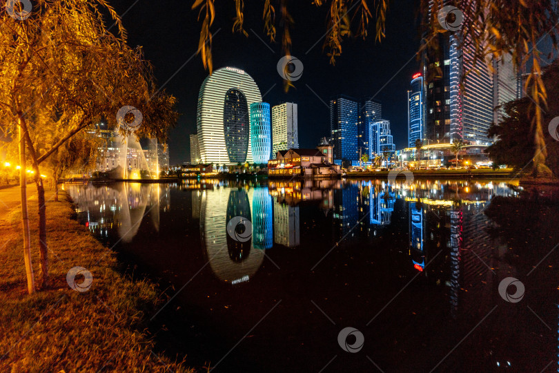 Скачать Ночная панорама небоскребов Батуми. Небоскребы отражаются в воде озера фотосток Ozero