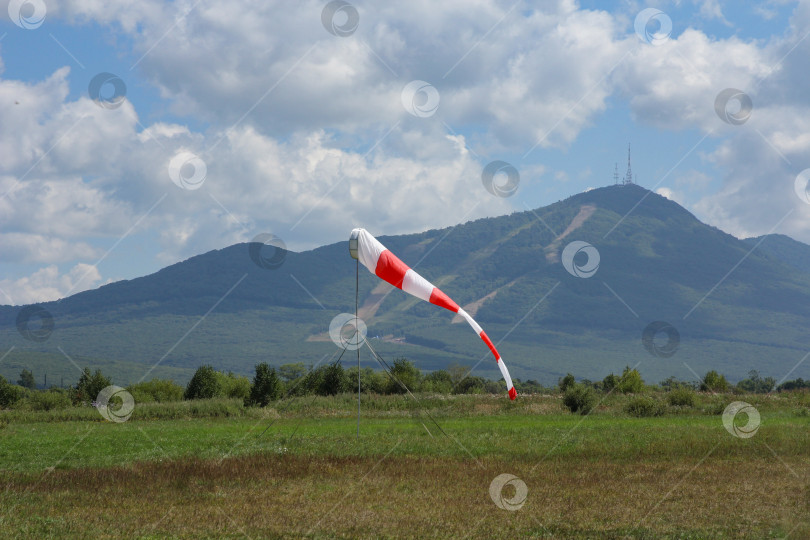 Скачать Потертый ветровой носок при умеренном ветре на фоне гор фотосток Ozero