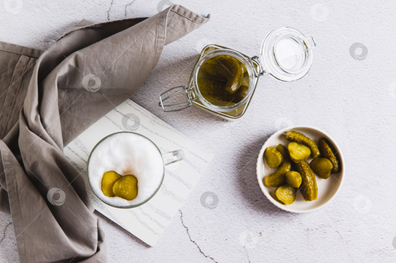 Скачать Латте с маринованными огурцами в бокале и в миске на столе вид сверху фотосток Ozero