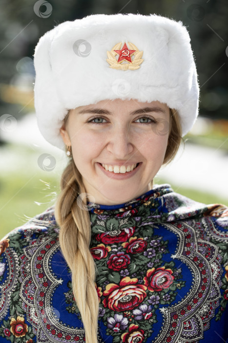 Скачать Портрет красивой молодой славянской девушки в белой меховой шапке-ушанке. фотосток Ozero