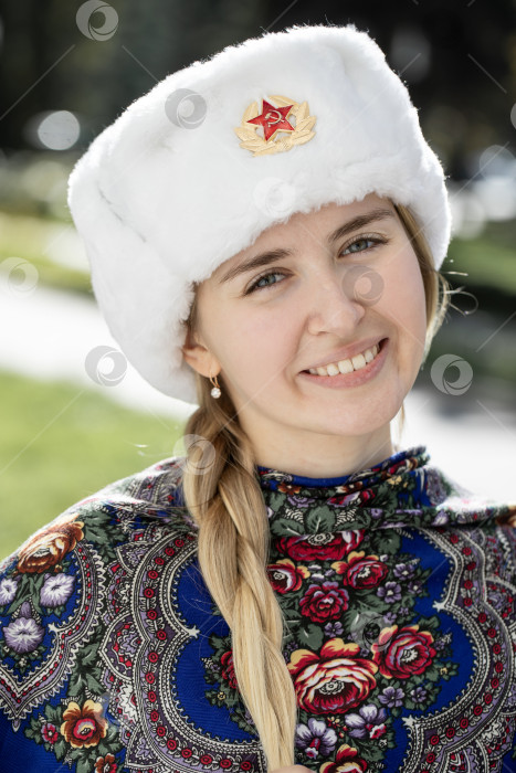 Скачать Портрет красивой молодой славянской девушки в белой меховой шапке-ушанке. фотосток Ozero