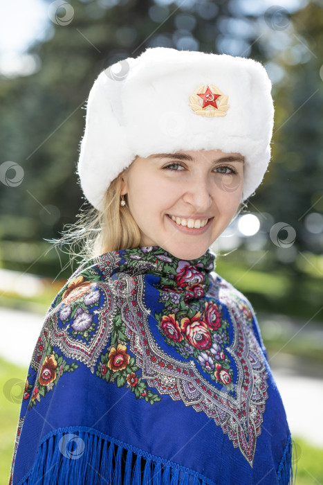 Скачать Портрет красивой молодой славянской девушки в белой меховой шапке-ушанке. фотосток Ozero