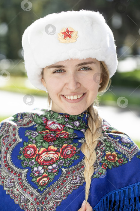 Скачать Портрет красивой молодой славянской девушки в белой меховой шапке-ушанке. фотосток Ozero